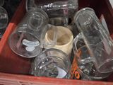 a red crate filled with empty glass jars on the shelf