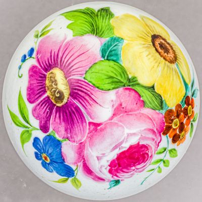 une assiette blanche sur laquelle sont peintes des fleurs colorées