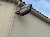 une enseigne sur le côté d'un immeuble, avec le ciel en arrière-plan