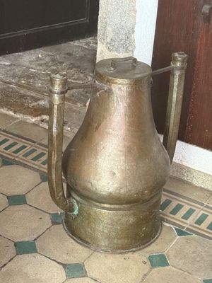 a large metal pot sitting on the floor in front of a door