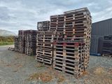 plusieurs palettes en bois empilées les unes sur les autres devant un bâtiment