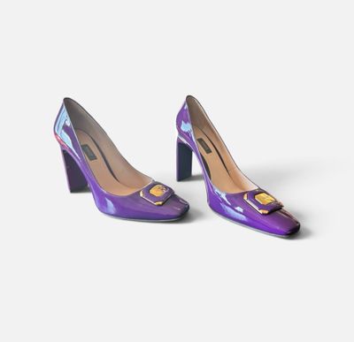 une paire d'escarpins violets avec un chat sur le talon