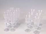 several clear wine glasses are lined up on a white surface