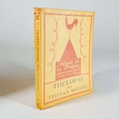 an old book with a yellow cover sitting on a white surface