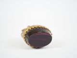 an image of a gold ring with a red stone on it