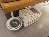 a bowl and a bowl on the floor next to a shelf