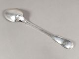 une cuillère en argent avec un manche de cuillère sur une table
