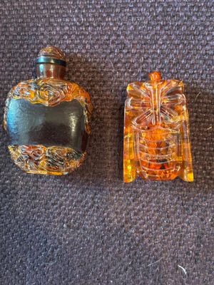deux petites bouteilles en verre posées l'une à côté de l'autre sur un tapis