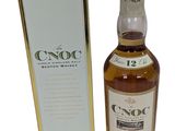 a bottle of whisky in front of a box on a white background