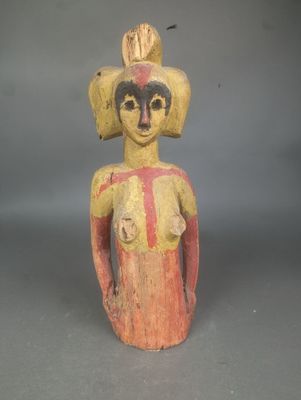 une vieille statue en bois représentant une femme coiffée d'un chapeau