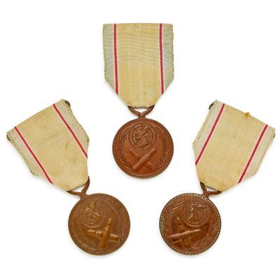 trois médailles avec leurs rubans et une médaille sur fond blanc