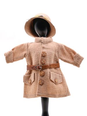 un mannequin vêtu d'un manteau et d'un chapeau, posé sur un socle