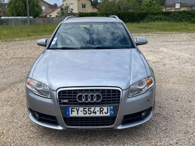 l'avant d'une voiture argentée garée sur un parking en gravier