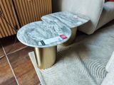 une table en marbre avec un piètement doré dans un salon