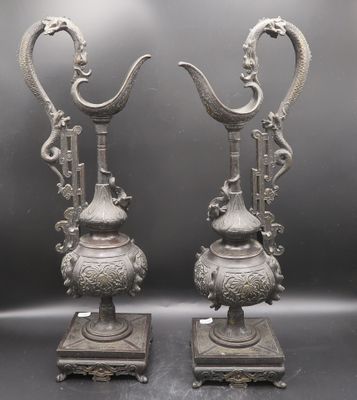 paire de vases anciens en bronze chinois, ornés de poignées en forme de dragon, posés sur des socles