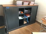 books are stacked on top of a cabinet in an office
