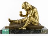bronze statue of a man sitting on a marble base with a cigarette in his hand