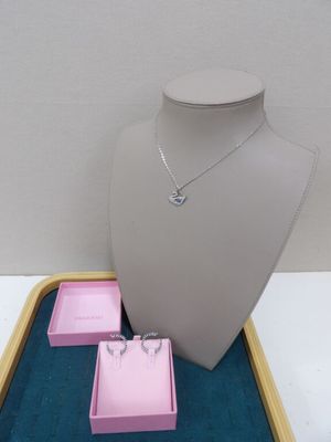 un collier et des boucles d'oreilles exposés sur un plateau dans une vitrine