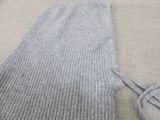 a sweater that is laying on the floor next to a pair of scissors