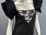 an image of a mannequin wearing a black dress with ruffled sleeves