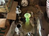 a small table with a glass vase and a clock on it