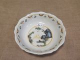 a small bowl with a painting on it sitting on a table
