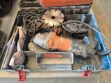 une boîte à outils contenant des outils, posée sur le sol
