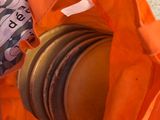 un sac orange contenant une pile de hamburgers