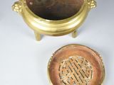 an image of a gold plate with a lid and a small bowl