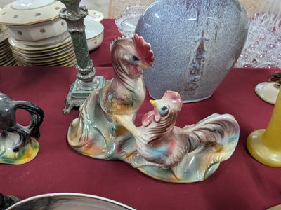 a table with a red table cloth covered with plates and vases