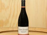 une bouteille de vin posée sur un tonneau