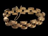 gros plan d'un bracelet en or sur fond noir