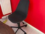 a black chair sitting in front of a red wall