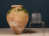 a large vase sitting next to a chair in a room