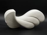 a white sculpture on a black surface with a black background