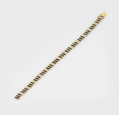 un bracelet en or à rayures noires et blanches sur fond blanc