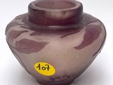 un vase violet sur lequel est collé un autocollant jaune