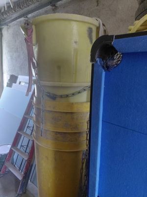 a yellow bucket sitting on top of a blue container
