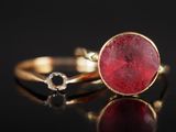 gros plan d'une bague en or avec une pierre rouge