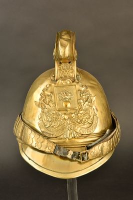 casque doré posé sur un socle, sur fond noir