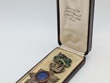 an image of a small box with a broochet and a medal in it