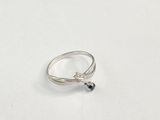 un gros plan d'une bague posée sur une surface blanche, ornée d'un diamant noir