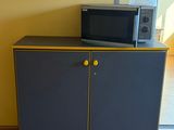 un micro-ondes posé sur un meuble dans une pièce