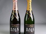 two bottles of champagne are shown next to each other on a table