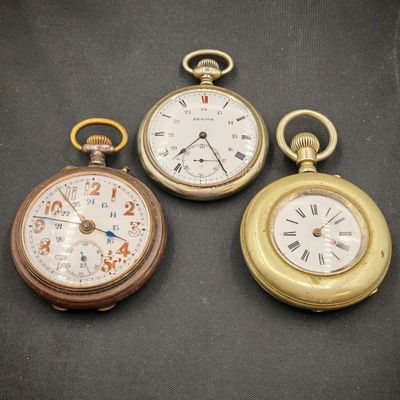 trois types différents de montres de poche sur un fond noir