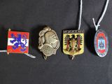 four different badges are hanging from a string on a black surface