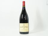 une bouteille de vin rouge posée sur une table blanche