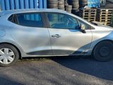 une voiture argentée garée à côté d'un tas de pneus