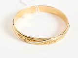 an image of a close up of a gold bracelet on a white surface