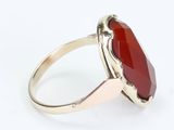 a close up of a ring with a red stone in it